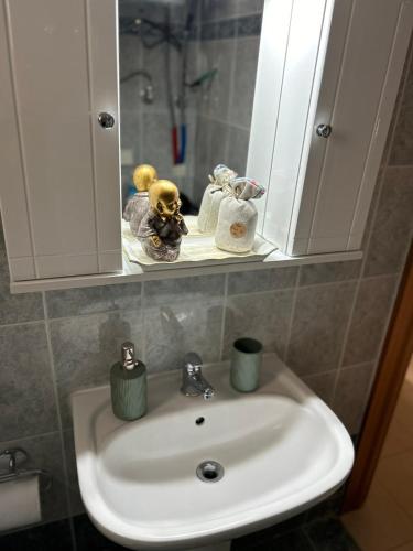 a bathroom sink with a teddy bear sitting on it at Elxie House in Xanthi