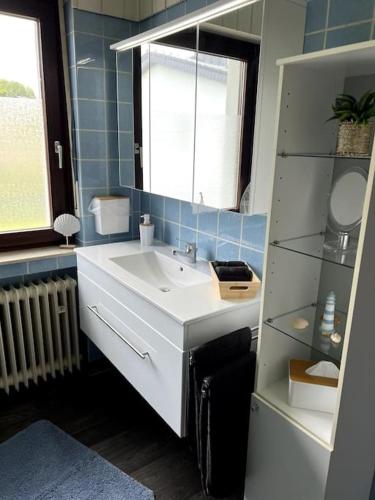 a bathroom with a white sink and a mirror at Ferienwohnung in Heuchelheim in Heuchelheim