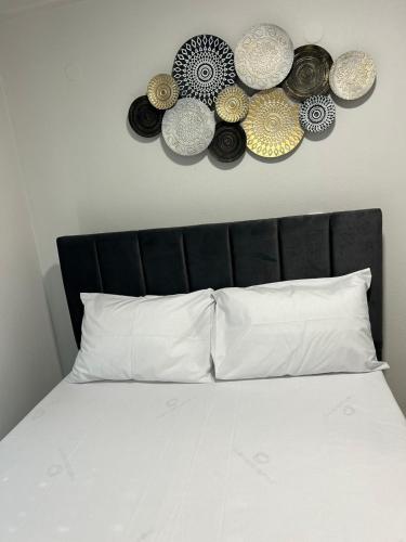 a bed with a black headboard with plates on the wall at Elxie House in Xanthi