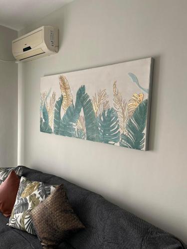 a painting hanging on a wall next to a couch at Elxie House in Xanthi