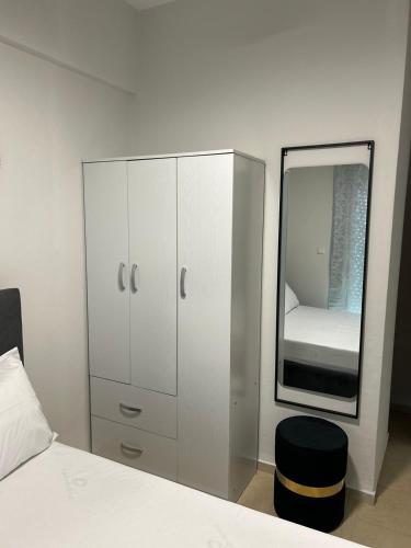 a white bedroom with a mirror and a bed at Elxie House in Xanthi