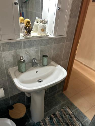 a bathroom with a white sink and a mirror at Elxie House in Xanthi