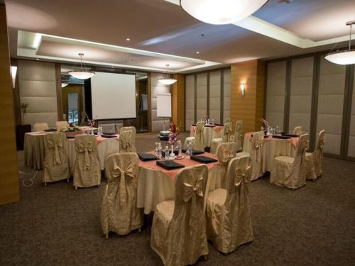 a conference room with tables and chairs and a screen at Executives Hotel - Olaya in Riyadh