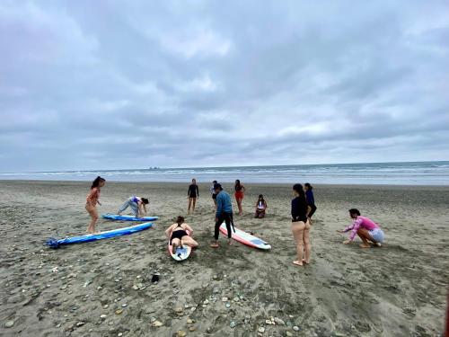 a group of people on a beach with surfboards at Hermanos Perdidos Surf in Las Tunas