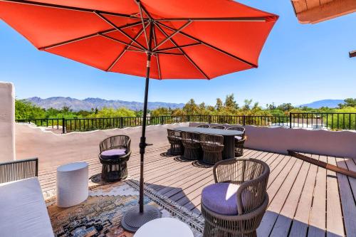 a patio with a red umbrella and tables and chairs at Lodge On The Desert in Tucson