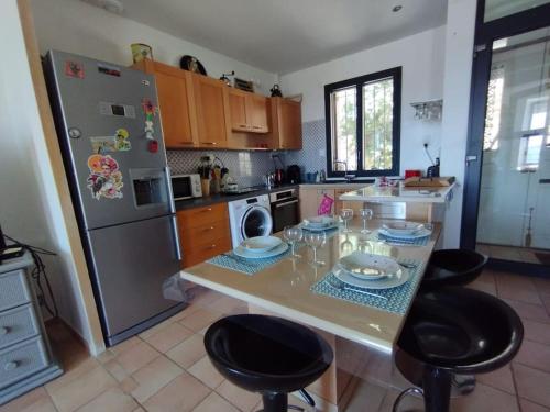 une cuisine avec une table avec des chaises et un réfrigérateur dans l'établissement Vue fabuleuse lagune de mer, à Bages