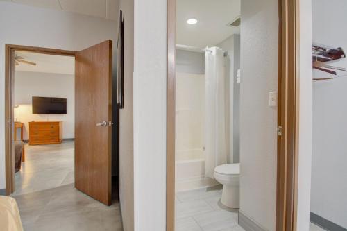 a bathroom with a toilet and a television in a room at Quality Inn & Suites CVG Airport in Erlanger
