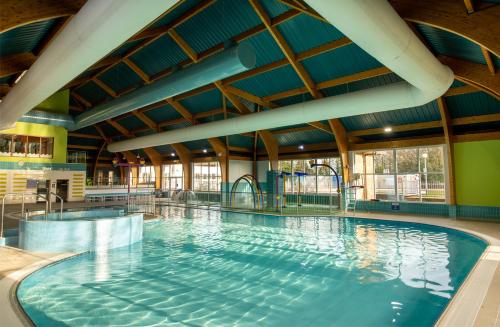 a large indoor swimming pool with blue water at Premium Holiday Home in The New Forest at Hoburne Bashley - Leisure Passes Available to Purchase in New Milton