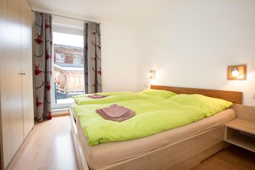a bedroom with a bed with a green blanket on it at Chalet Central Top CC 6 in Königsleiten