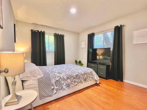 a bedroom with a bed and a flat screen tv at KING SUITE 2BR Home w FAST WiFi, & WFH Desk in San Antonio