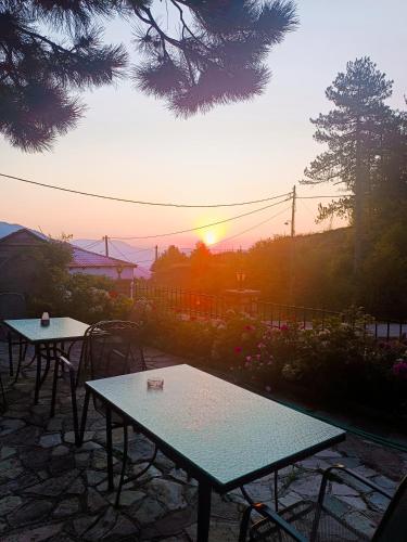 two tables and chairs with the sunset in the background at O Elatos in Loutra Amarantou