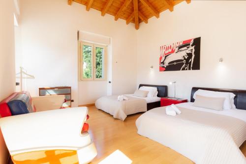 a room with three beds and a couch at Luxury Villa Laglio in Laglio