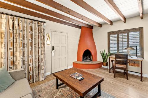 a living room with a fireplace and a table at Lodge On The Desert in Tucson