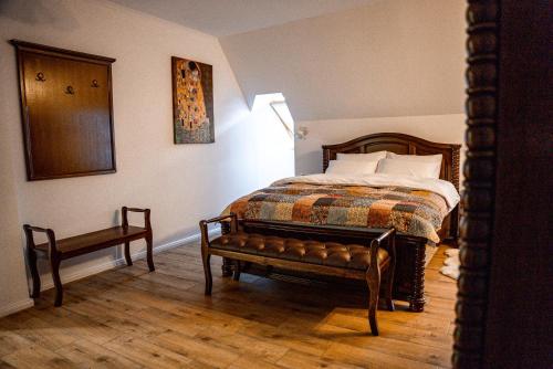 a bedroom with a bed and a bench in it at Boutique Marlen in Ghimbav
