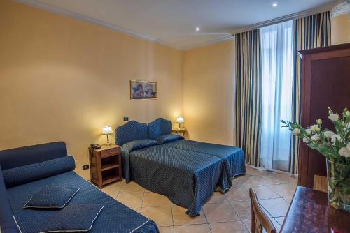 a hotel room with a bed and a couch at Hotel Caracciolo in Rome