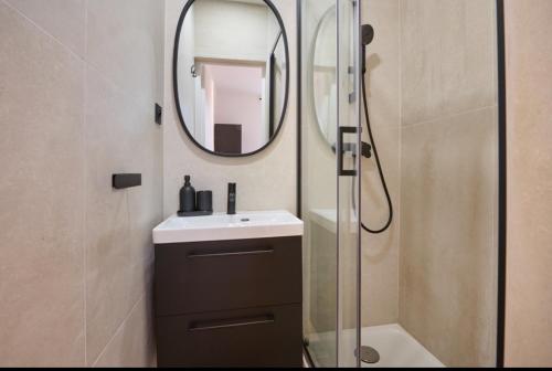une salle de bain avec un lavabo et un miroir dans l'établissement Eiffel Appartement, à Paris