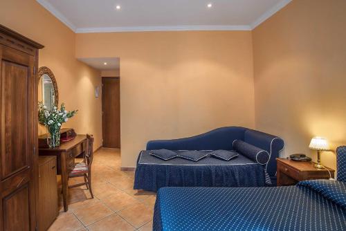 a living room with a blue couch and a table at Hotel Caracciolo in Rome