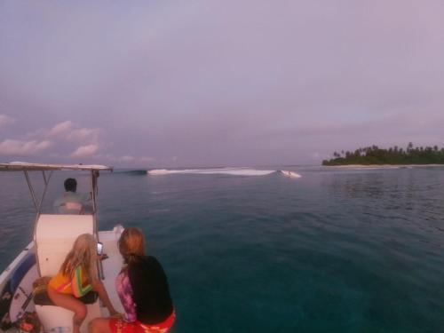 two people sitting on the back of a boat in the water at Finimas Residence in Thimarafushi