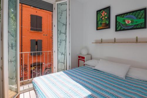 a bedroom with a bed and a large window at Appartamento Capodilucca in Bologna