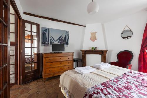 1 dormitorio con cama y vestidor con TV en Appartement authentique à colombage 15mn de Disney, en Ferrières-en-Brie