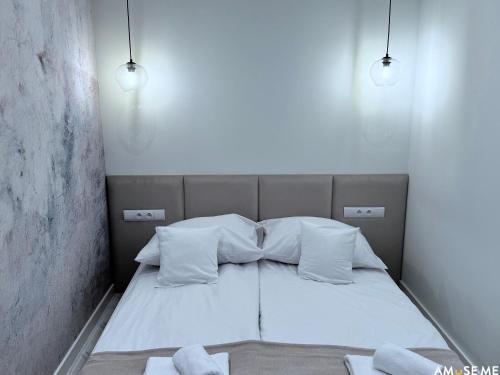 a small bedroom with a bed with two pillows at AMuSE ME in Kielce
