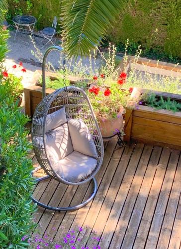 a wicker chair sitting on a deck in a garden at Villa Oleander, Mougins in Mougins