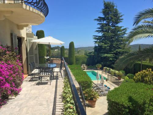 a patio with a table and chairs next to a pool at Villa Oleander, Mougins in Mougins