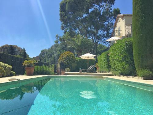 a swimming pool with blue water in a yard at Villa Oleander, Mougins in Mougins