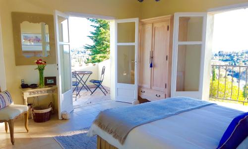 a bedroom with a large bed and a balcony at Villa Oleander, Mougins in Mougins
