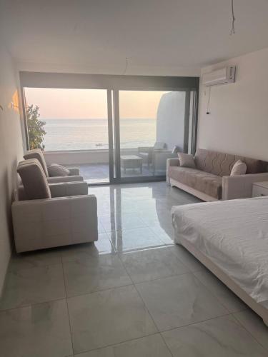 a bedroom with a bed and couches and the ocean at ALOHA Beach front Vacation Rental in Ulcinj