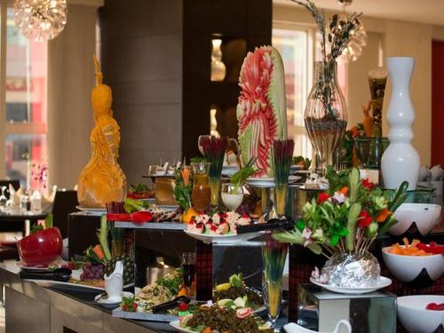 a buffet with many plates of food and vases at Executives Hotel - Olaya in Riyadh