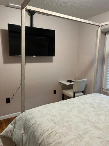 a bedroom with a bed and a flat screen tv on the wall at Sunny Lavender Canopy Retreat in Cleveland