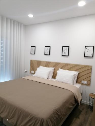 a bedroom with a large bed with four pictures on the wall at Refúgio Vale da Pipa in Figueiró dos Vinhos