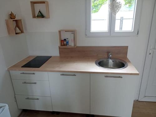 un comptoir de cuisine avec un évier et une fenêtre dans l'établissement studio calme entre Montpellier et la mer, à Saussan