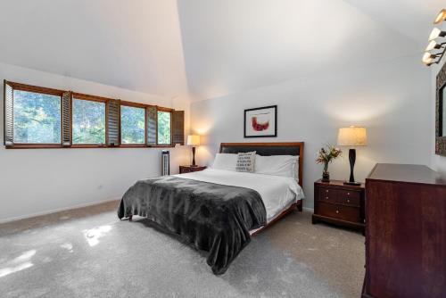 a bedroom with a bed and a dresser and windows at Spacious 3BR Redmond Home with Fireplace & BBQ in Redmond
