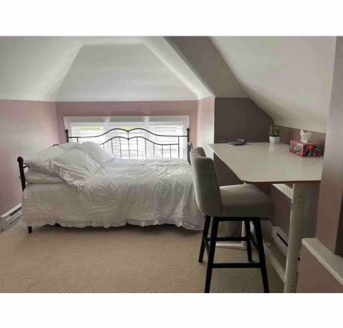 a bedroom with a white bed and a desk and a desk at Elevated Entertainment Sleep Suite in Cleveland