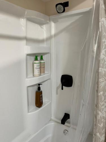 a bathroom with a bath tub with two bottles of soap at Elevated Entertainment Sleep Suite in Cleveland