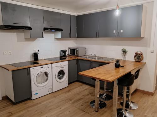 a kitchen with a washing machine and a wooden table at Paris cosy private room with shared space - Chambre privée avec espace commun Paris in Vitry-sur-Seine