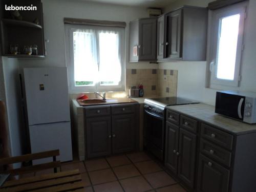 - une cuisine avec des placards gris, un évier et une cuisinière dans l'établissement l'olivade, à La Seyne-sur-Mer