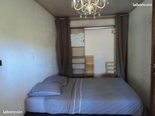 - une chambre avec un lit, une fenêtre et un lustre dans l'établissement l'olivade, à La Seyne-sur-Mer