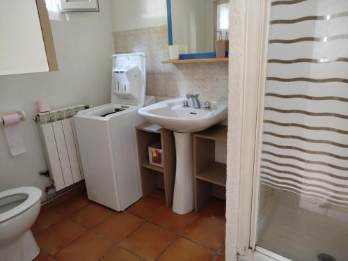 une salle de bain avec un lavabo et une machine à laver dans l'établissement l'olivade, à La Seyne-sur-Mer