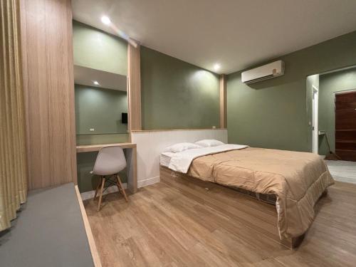 a bedroom with a bed and a desk and a chair at เดอเนส บูติก โฮมสเตย์ C9 Denest Boutique Homestay in Ban Phai