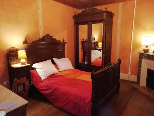 a bedroom with a large bed and a mirror at Domaine du Baron in Saint-Martin-lʼAstier