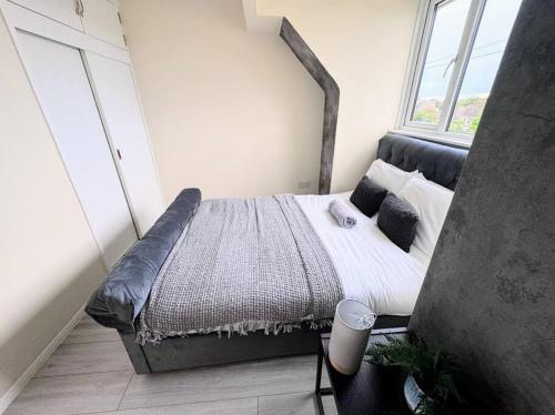 a bedroom with a large bed with a large window at Folkstone Luxury Spacious House in Folkestone