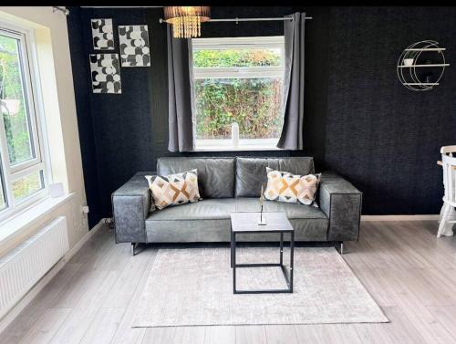 a living room with a couch and a table at Folkstone Luxury Spacious House in Folkestone