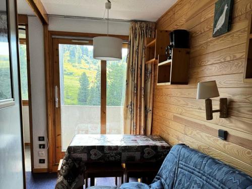 Cette petite chambre dispose d'une table et d'une fenêtre. dans l'établissement Résidence Onyx - Studio pour 4 Personnes 77, à Mâcot La Plagne
