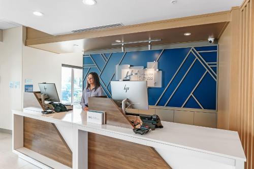 a woman standing at a counter in an office at Holiday Inn Express and Suites - Nokomis - Sarasota South in Nokomis