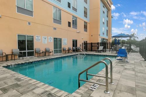 a swimming pool with chairs and a building at Holiday Inn Express and Suites - Nokomis - Sarasota South in Nokomis