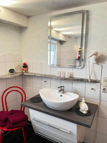 a bathroom with a sink and a mirror at Ferienwohnung im Leuchtturmort Bastorf in Bastorf