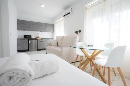 una habitación blanca con una cama y una mesa en L&G APARTMENTS BAHíA SUITE, en Alicante